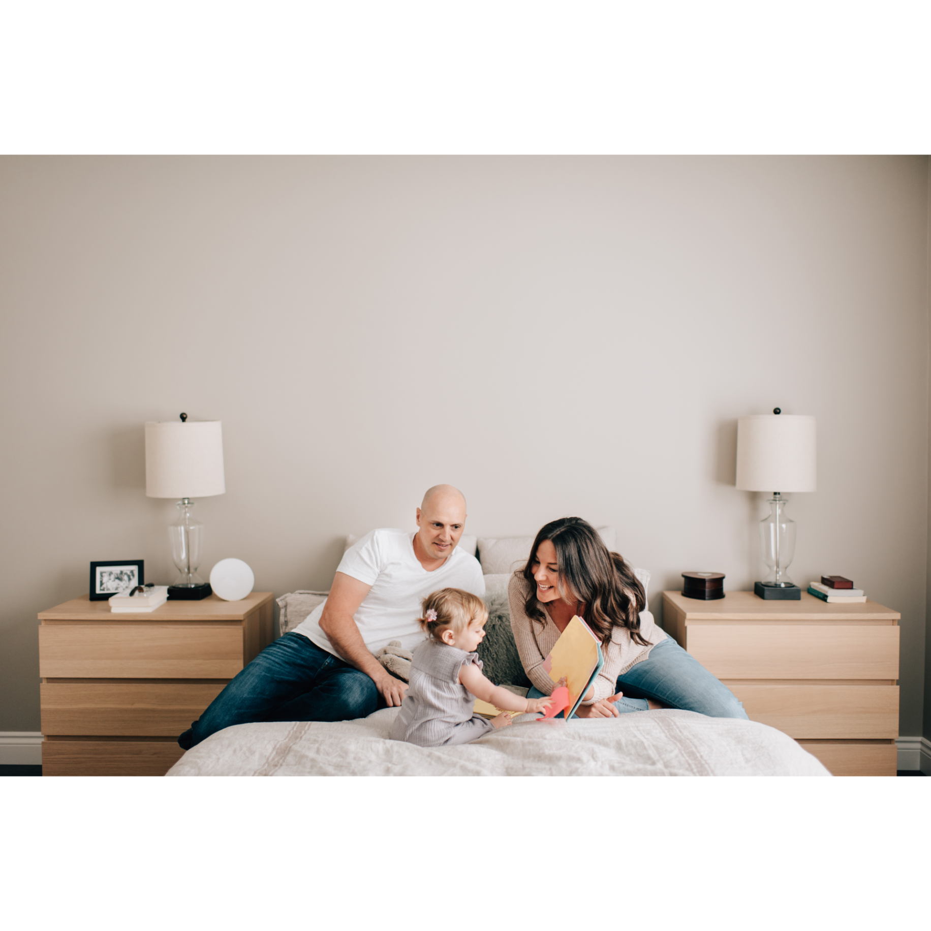 bedroom design for wellness.Young parents reading with their toddler on a bed in a minimalist, wellness-focused bedroom designed for better indoor air quality and sleep.