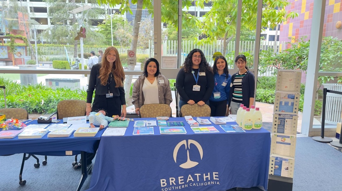 Breathe Southern California team at community health event with educational materials on asthma and allergies and Kleenex® Air Filters