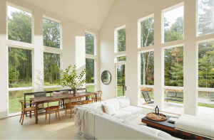 Living and dining room with large windows and walls painted in Benjamin Moore Eco Spec® Dove Wing, a CERTIFIED asthma & allergy friendly® low VOC paint.